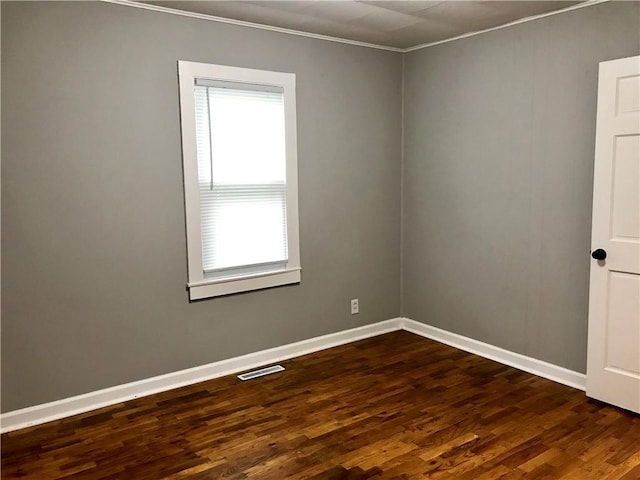 spare room with dark hardwood / wood-style flooring and ornamental molding