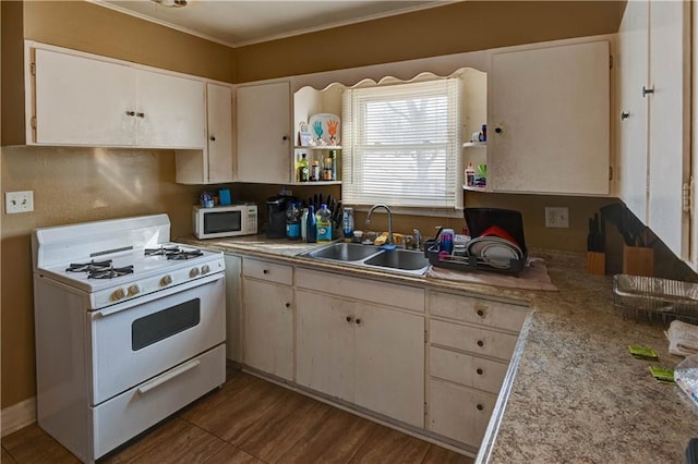 kitchen featuring sink, white appliances, white cabinets, and ornamental molding