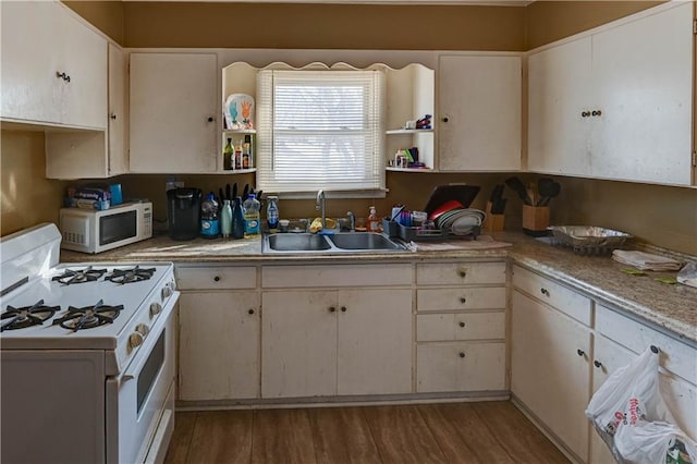 kitchen with sink, white cabinets, hardwood / wood-style flooring, and white appliances