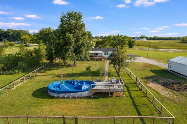 exterior space featuring a lawn, a rural view, and a pool side deck