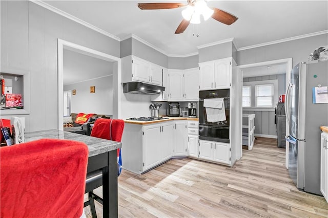 kitchen with gas stovetop, white cabinetry, ornamental molding, and stainless steel refrigerator