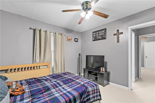 carpeted bedroom with ceiling fan and a textured ceiling