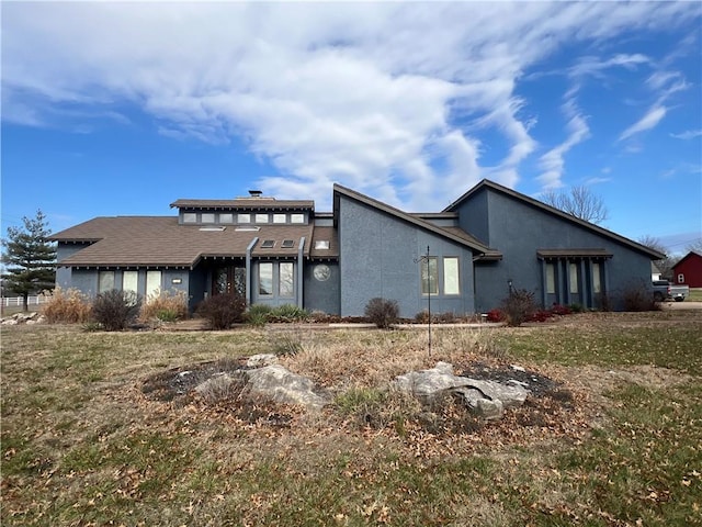 rear view of property featuring a lawn