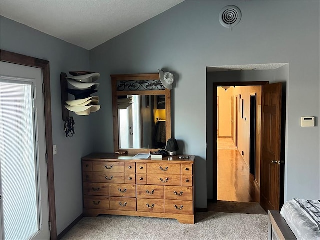 bedroom featuring visible vents, vaulted ceiling, and light carpet