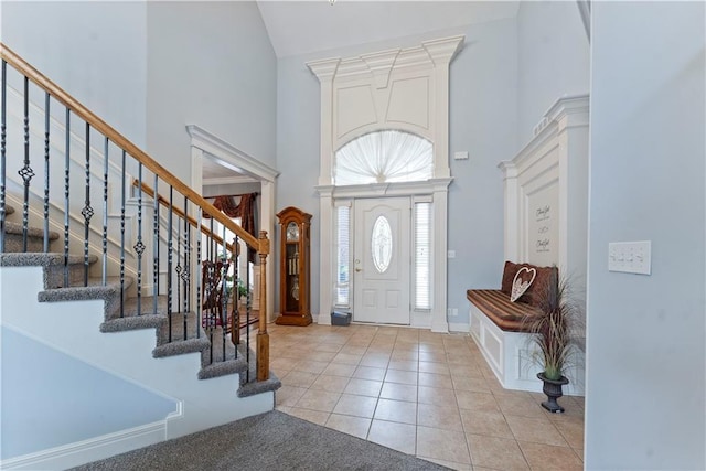 entrance foyer featuring light tile patterned flooring and a towering ceiling