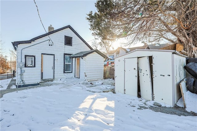 snow covered property with a storage unit