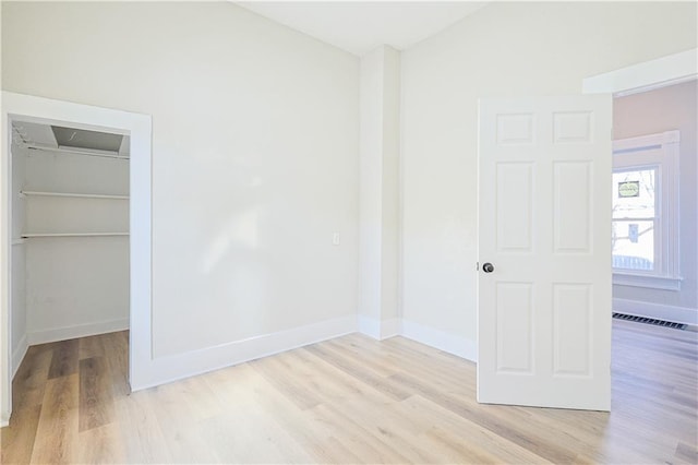 unfurnished bedroom with a closet and light hardwood / wood-style flooring