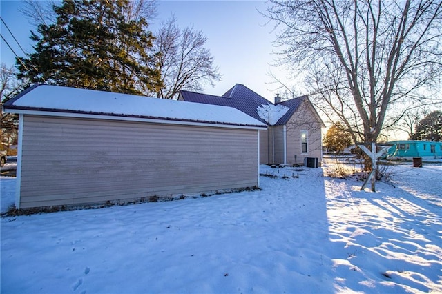 snow covered property with central AC unit