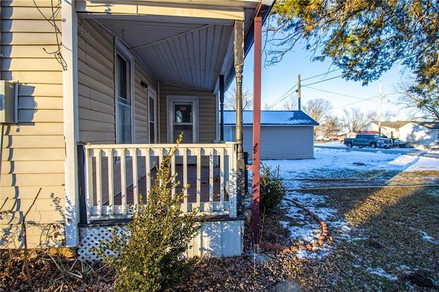 view of snowy exterior featuring covered porch