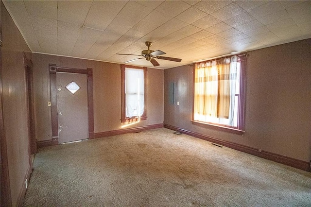 spare room with carpet floors, ceiling fan, and a healthy amount of sunlight