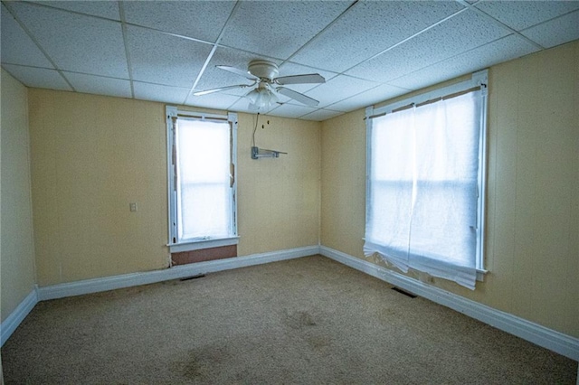 carpeted spare room featuring ceiling fan and a paneled ceiling