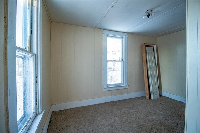 unfurnished room featuring wood walls