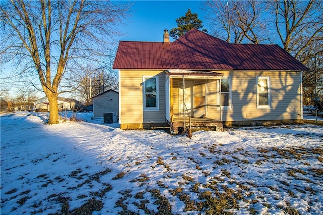 view of snow covered rear of property