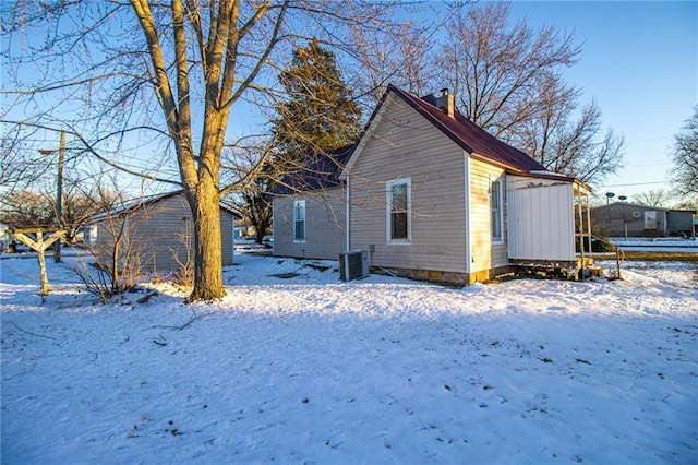 view of snow covered exterior with cooling unit