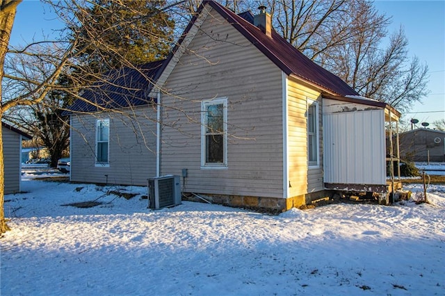 snow covered property featuring cooling unit