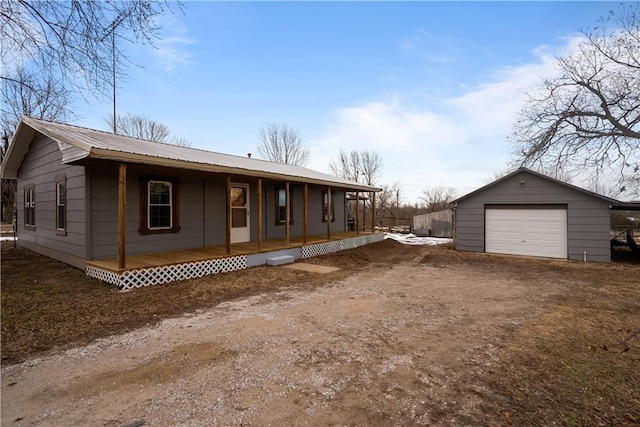 exterior space featuring covered porch, a garage, and an outdoor structure