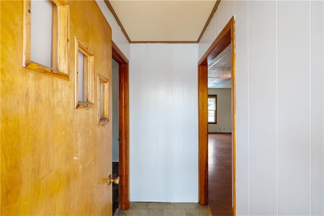 hallway featuring crown molding and wooden walls