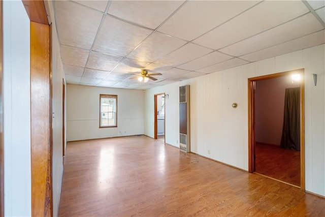 empty room featuring ceiling fan, a paneled ceiling, and hardwood / wood-style flooring