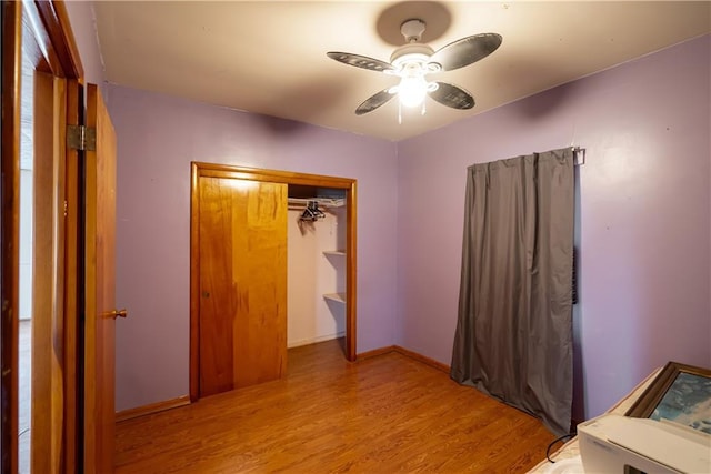 unfurnished bedroom featuring light wood-type flooring, ceiling fan, and a closet