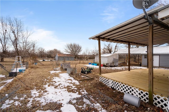 yard covered in snow with a deck