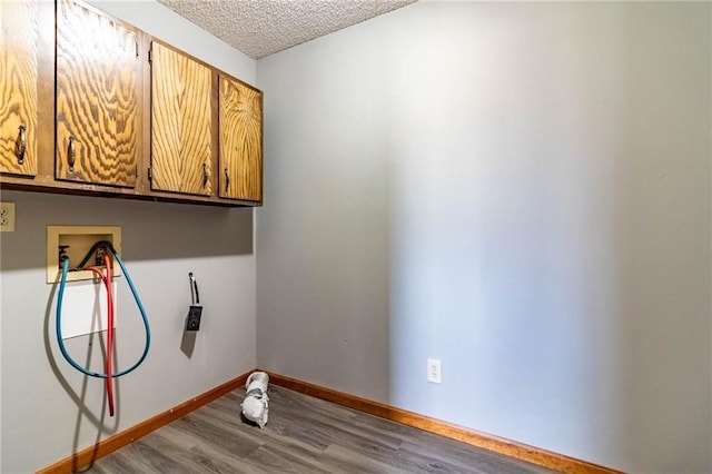 laundry area with cabinets, washer hookup, wood-type flooring, and a textured ceiling