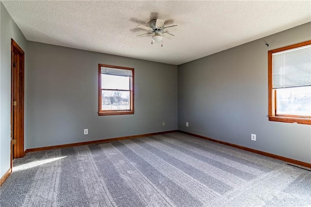 spare room featuring ceiling fan, carpet, and a textured ceiling