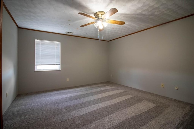 carpeted spare room with ceiling fan, ornamental molding, and a textured ceiling