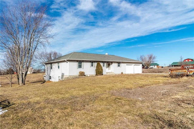 back of house featuring a garage and a yard