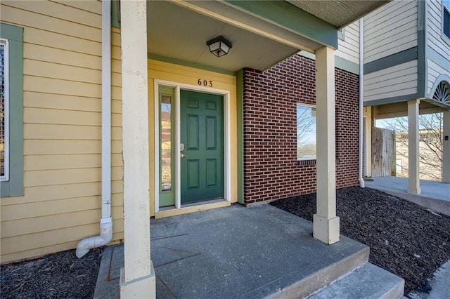 property entrance featuring brick siding