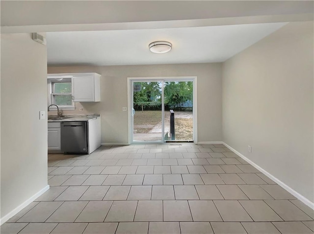 interior space with stainless steel dishwasher, white cabinets, sink, and light tile patterned floors