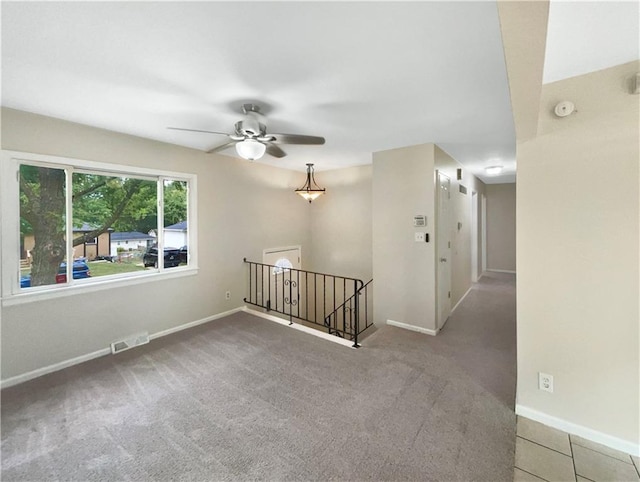 carpeted spare room featuring ceiling fan