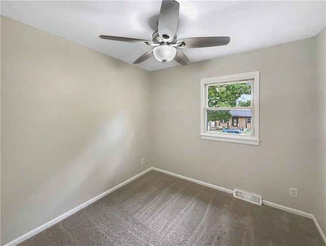 spare room featuring ceiling fan and dark colored carpet