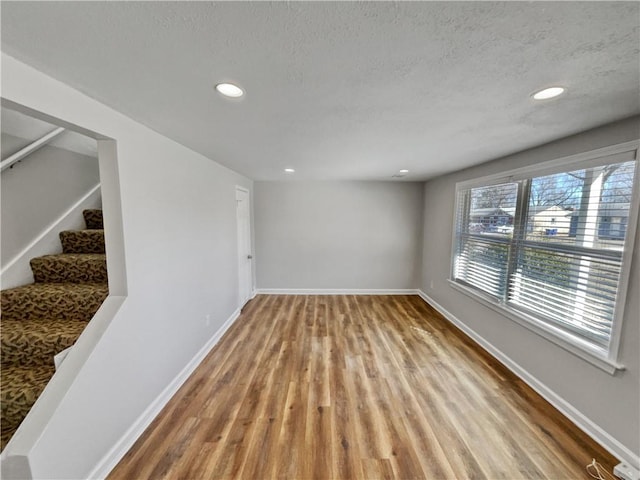 spare room with light hardwood / wood-style floors and a textured ceiling