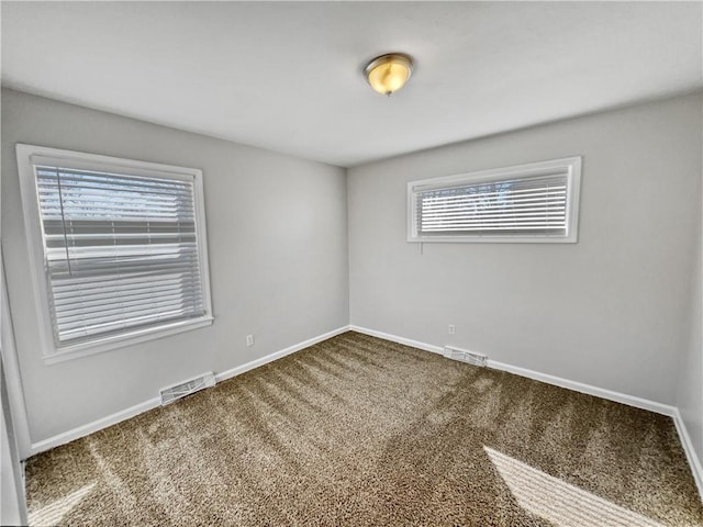 unfurnished room featuring a wealth of natural light and carpet