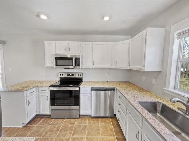 kitchen featuring plenty of natural light, appliances with stainless steel finishes, white cabinets, and sink