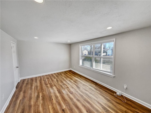 empty room with a textured ceiling and hardwood / wood-style floors