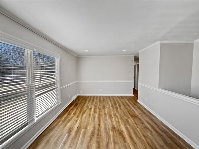 spare room featuring a wealth of natural light, crown molding, and light hardwood / wood-style flooring