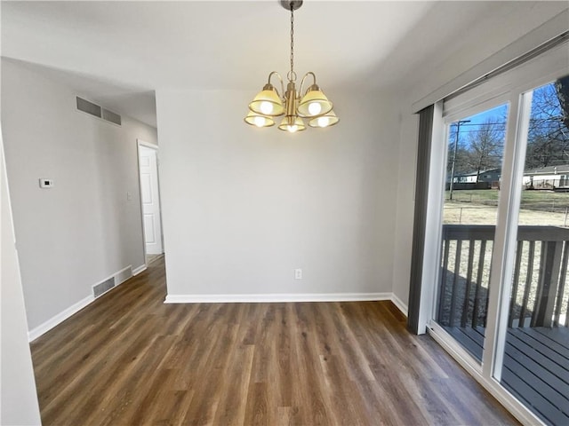 spare room featuring dark hardwood / wood-style flooring and a notable chandelier