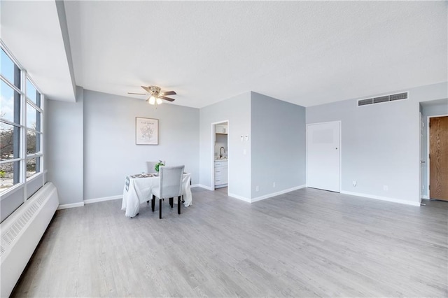 unfurnished dining area featuring hardwood / wood-style floors, sink, and ceiling fan