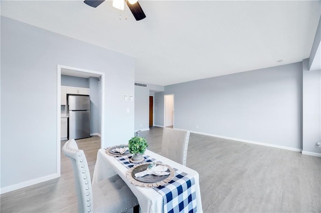 dining space with ceiling fan and light wood-type flooring