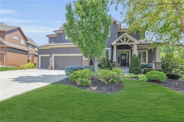 craftsman house with a garage, concrete driveway, stone siding, a front lawn, and stucco siding