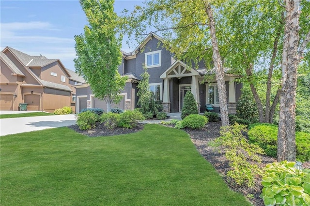 craftsman house featuring a garage, concrete driveway, a front lawn, and stucco siding