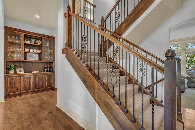 stairs featuring recessed lighting, visible vents, baseboards, and wood finished floors