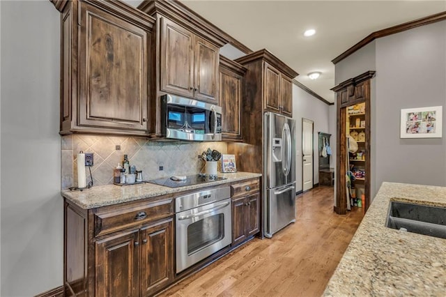 kitchen featuring backsplash, appliances with stainless steel finishes, light wood-style floors, ornamental molding, and dark brown cabinetry