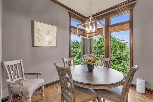 dining area with light wood-style flooring, a chandelier, and baseboards