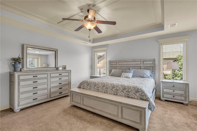 bedroom with a raised ceiling, visible vents, light carpet, and multiple windows