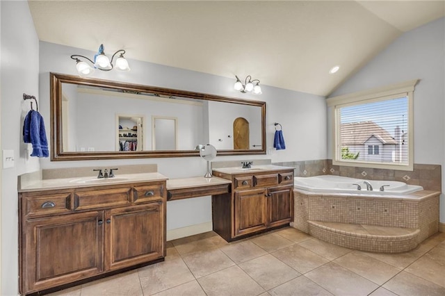 bathroom with tile patterned floors, vaulted ceiling, a bath, and vanity