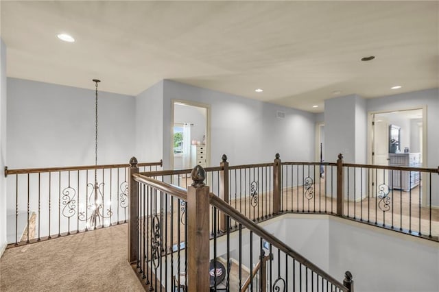 hallway featuring visible vents, carpet, an upstairs landing, a notable chandelier, and recessed lighting