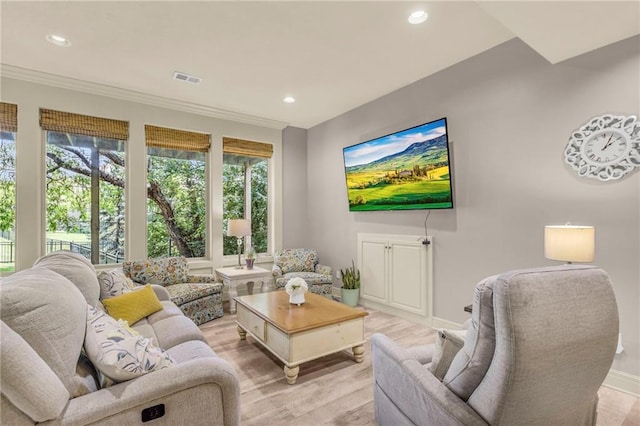 living area featuring light wood finished floors, visible vents, baseboards, ornamental molding, and recessed lighting