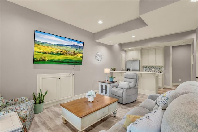 living room featuring light wood finished floors, recessed lighting, and baseboards